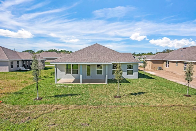 rear view of property featuring a yard and a patio area