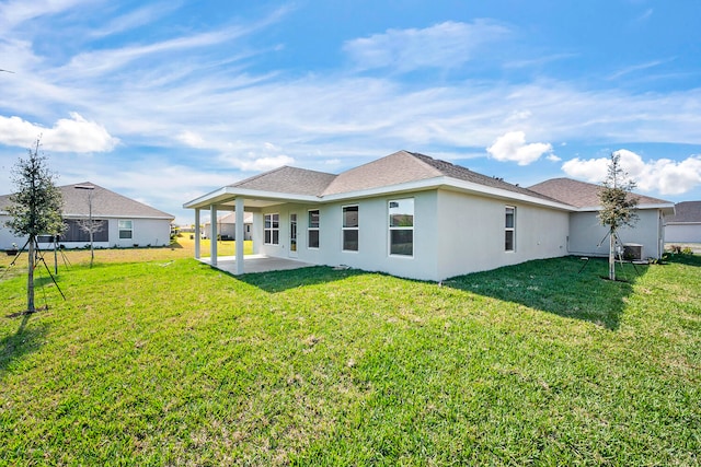 rear view of house with a yard, a patio, and central air condition unit