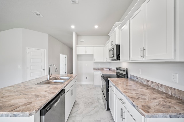 kitchen with appliances with stainless steel finishes, sink, white cabinetry, and an island with sink