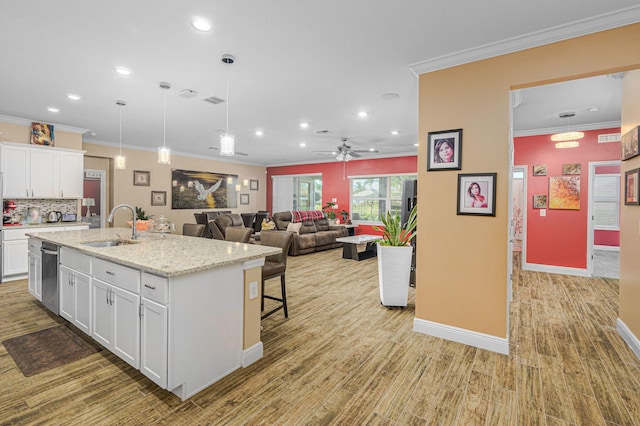 kitchen with ceiling fan, sink, light hardwood / wood-style flooring, a kitchen island with sink, and white cabinets