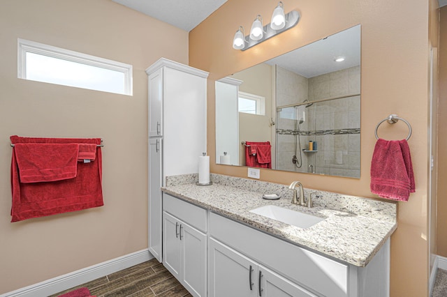 bathroom featuring a tile shower, vanity, and hardwood / wood-style flooring