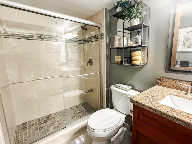 bathroom with vanity, toilet, and a shower with shower door