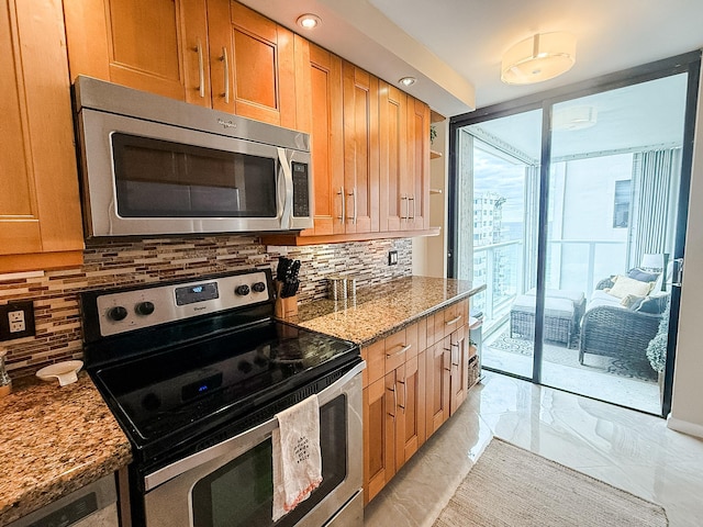 kitchen with backsplash, stainless steel appliances, and dark stone countertops