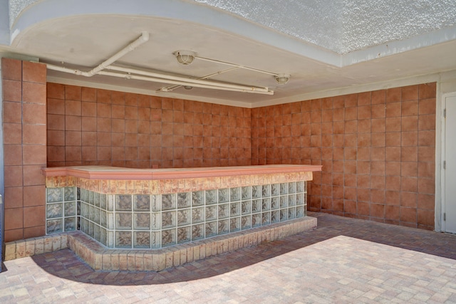 interior space with a textured ceiling and tile walls