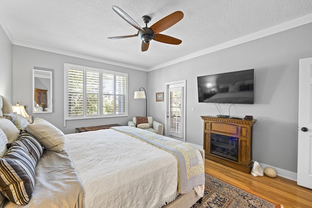 bedroom featuring ceiling fan, crown molding, wood-type flooring, and a textured ceiling