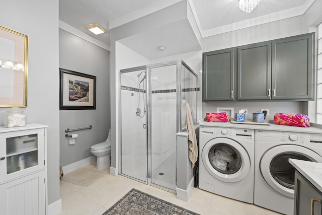 washroom with light tile patterned floors, washer and dryer, and a textured ceiling