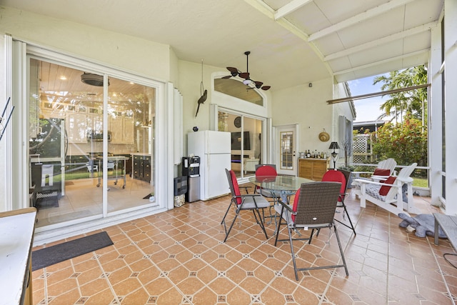 sunroom featuring vaulted ceiling with beams and ceiling fan