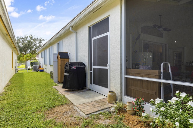 view of side of home featuring ceiling fan and a lawn