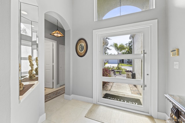 tiled entrance foyer featuring a towering ceiling