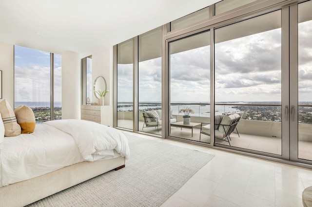 bedroom with access to outside, multiple windows, and a water view