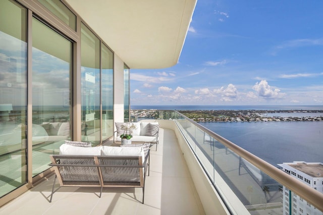 balcony featuring an outdoor living space and a water view