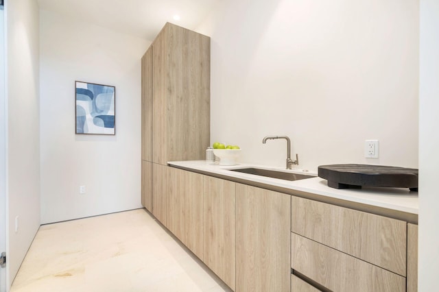 kitchen with light brown cabinetry and sink