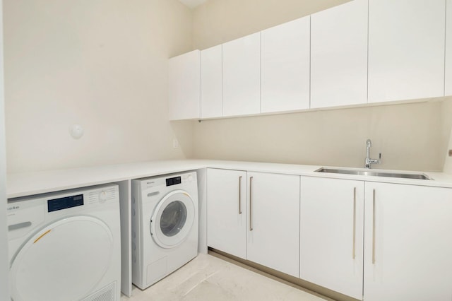 laundry area with washer and clothes dryer, cabinets, and sink