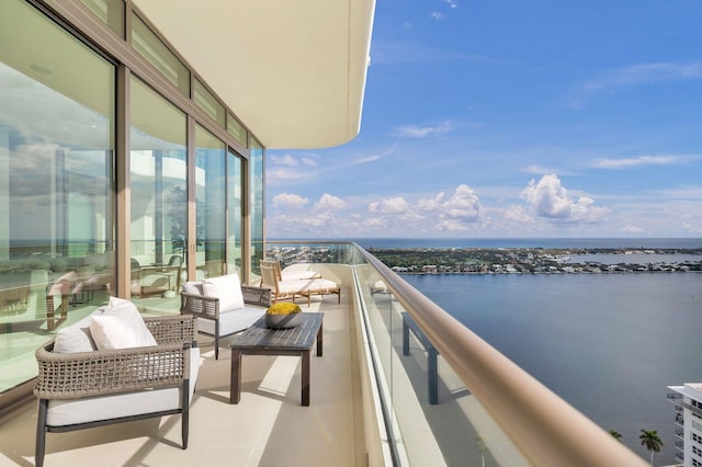 balcony with an outdoor hangout area and a water view