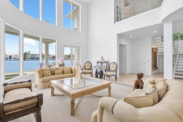 living room featuring a water view and a high ceiling