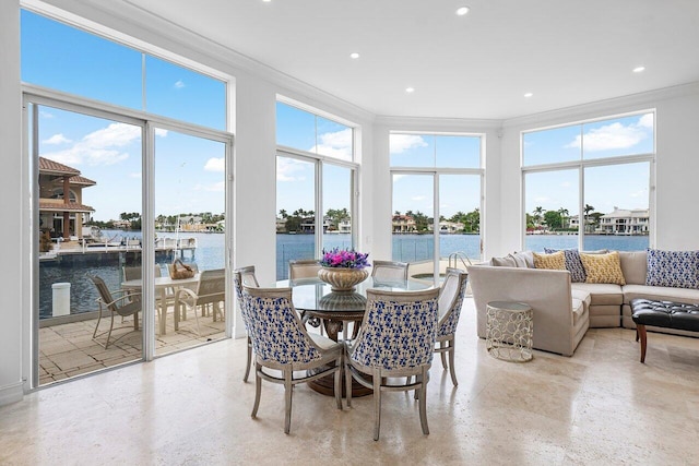 sunroom featuring a water view