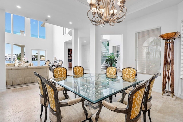 dining area with a high ceiling, an inviting chandelier, and crown molding