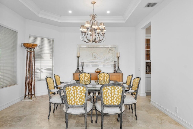 dining space featuring a raised ceiling, a chandelier, and ornamental molding