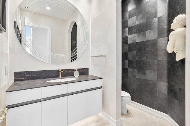 bathroom with tile patterned floors, vanity, toilet, and tile walls