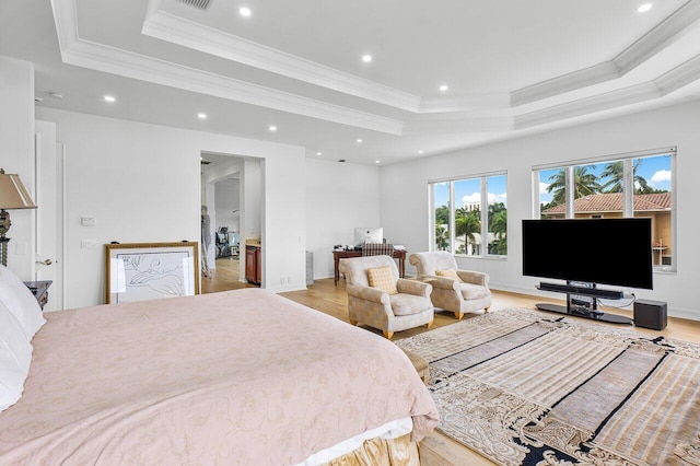 bedroom featuring a raised ceiling, crown molding, and light wood-type flooring