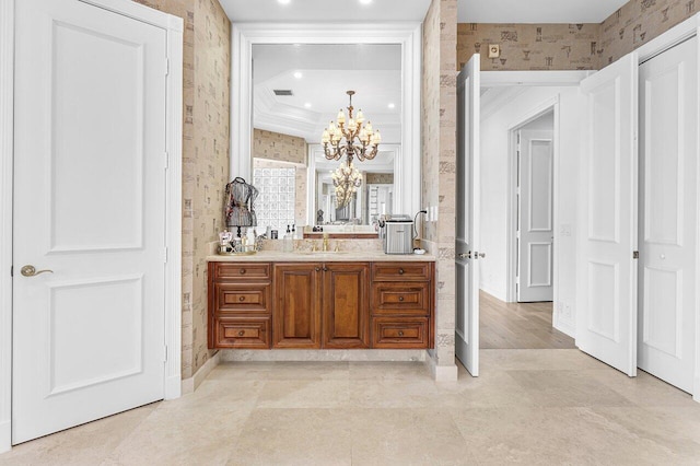 bathroom featuring vanity, ornamental molding, and a chandelier