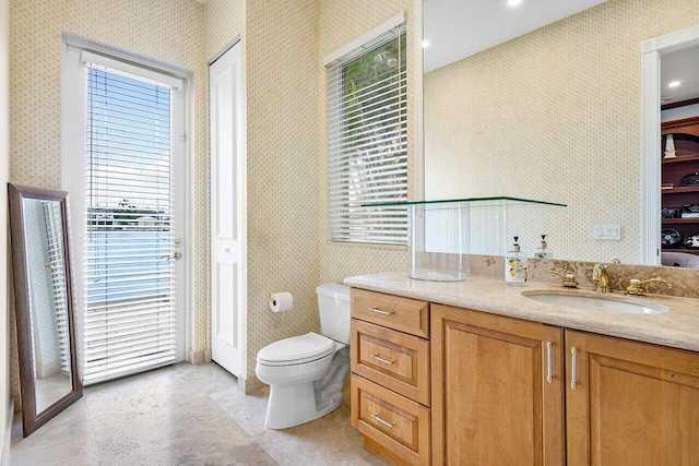 bathroom featuring plenty of natural light, vanity, and toilet