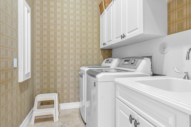 laundry room featuring cabinets, independent washer and dryer, and sink