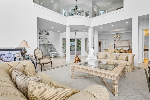 living room with french doors, a towering ceiling, and an inviting chandelier