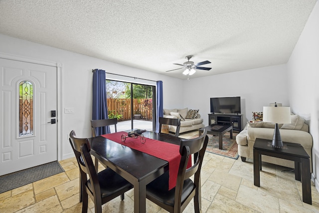 dining area with a textured ceiling and ceiling fan