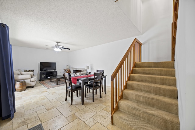 dining room featuring ceiling fan and a textured ceiling