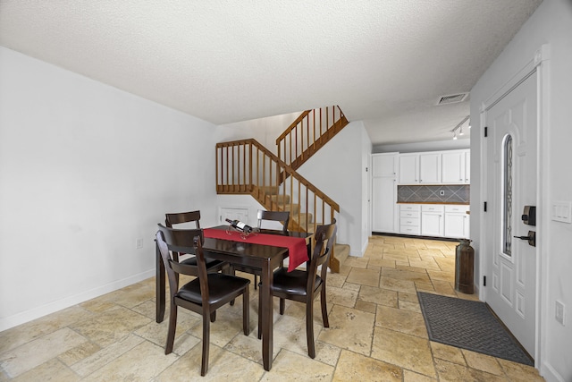 dining space featuring a textured ceiling