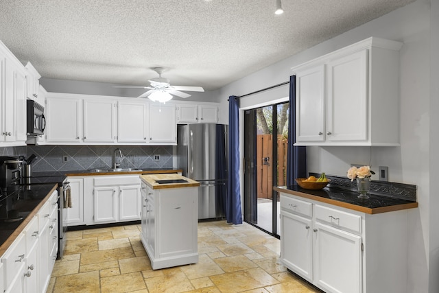 kitchen featuring decorative backsplash, ceiling fan, white cabinetry, and appliances with stainless steel finishes