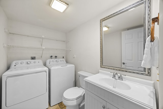 bathroom with vanity, washer and dryer, and toilet