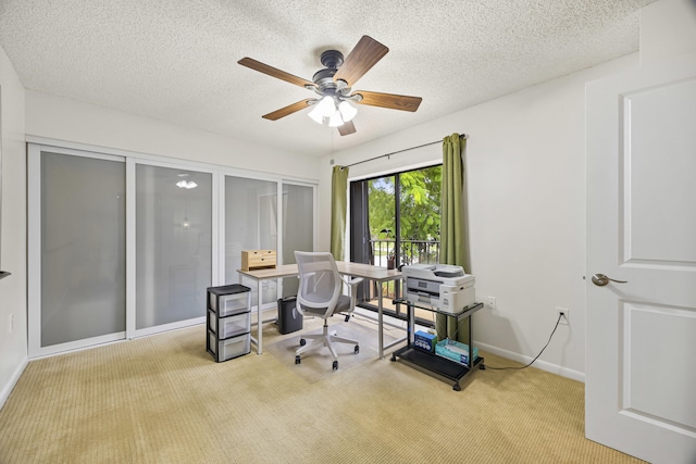 office area with ceiling fan, light colored carpet, and a textured ceiling