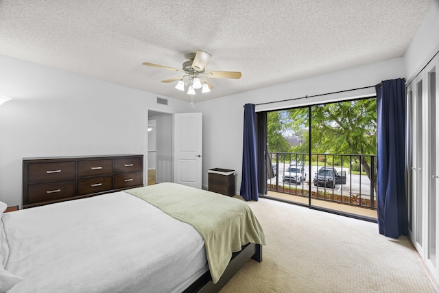 carpeted bedroom with access to exterior, ceiling fan, and a textured ceiling