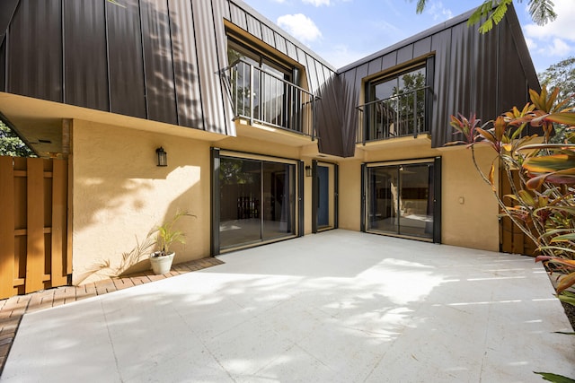 back of house featuring a balcony and a patio area