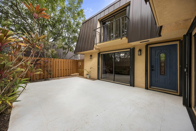 entrance to property with a balcony and a patio