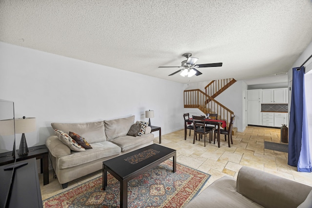 living room with ceiling fan and a textured ceiling