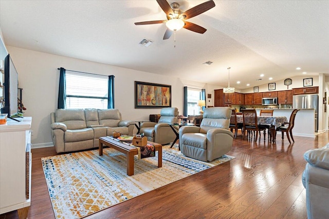 living room featuring ceiling fan, a healthy amount of sunlight, lofted ceiling, and hardwood / wood-style flooring