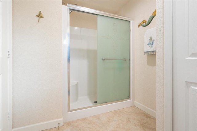 bathroom with a shower with door