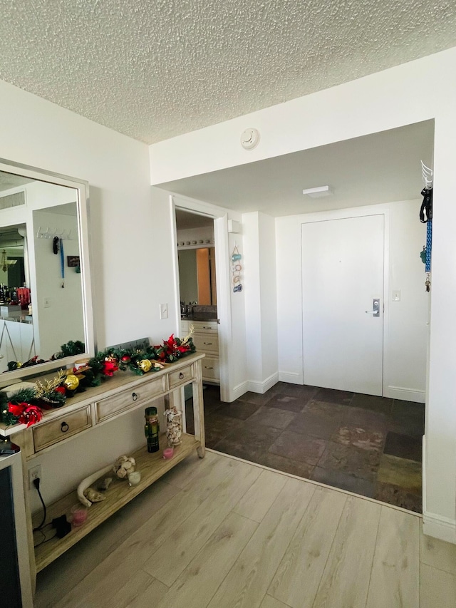 hall with a textured ceiling and hardwood / wood-style flooring