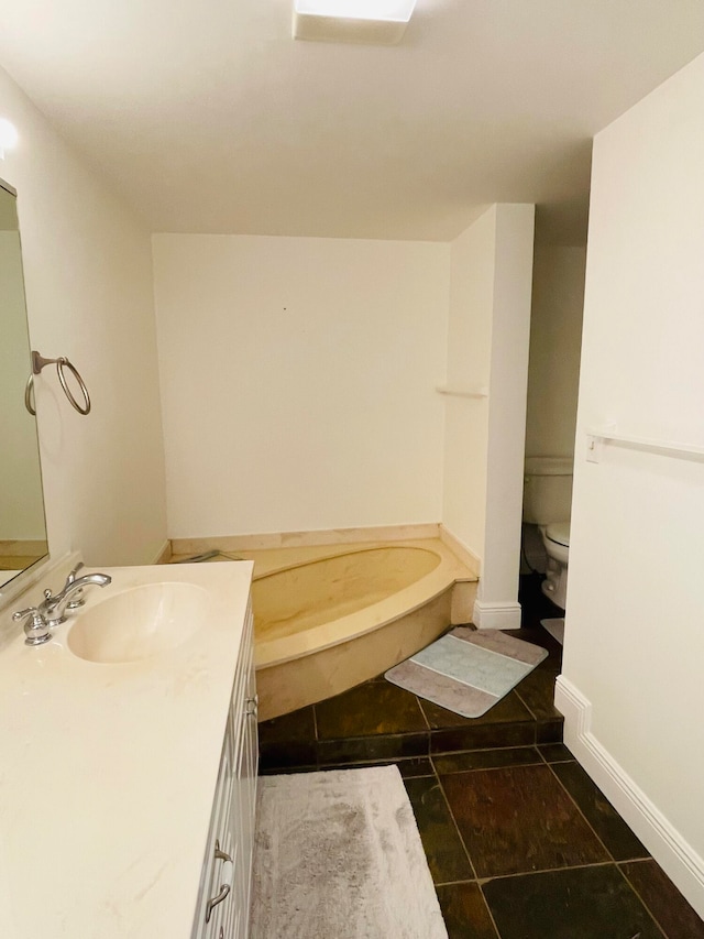 bathroom with tile patterned floors, a washtub, toilet, and vanity