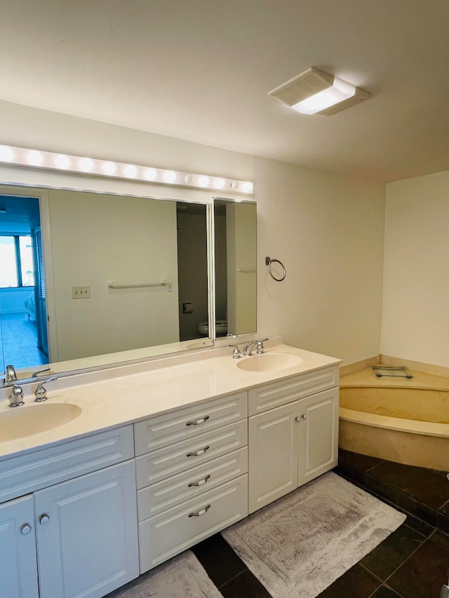 bathroom with tile patterned flooring, vanity, toilet, and a tub