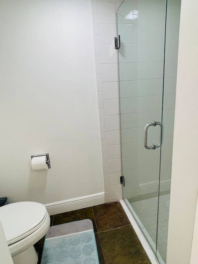 bathroom featuring tile patterned flooring, toilet, and a shower with shower door