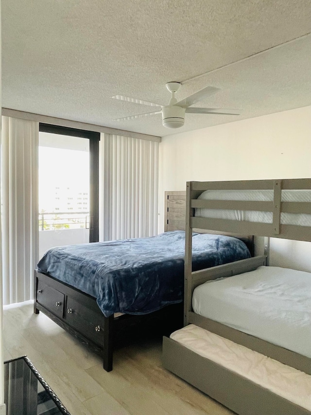 bedroom featuring ceiling fan, wood-type flooring, and a textured ceiling