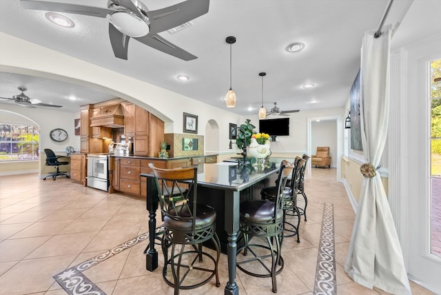 dining room featuring a textured ceiling, ceiling fan, and light tile patterned flooring