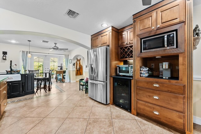 kitchen with french doors, hanging light fixtures, wine cooler, appliances with stainless steel finishes, and light tile patterned flooring