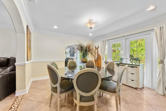 tiled dining space featuring french doors, a textured ceiling, and ornamental molding