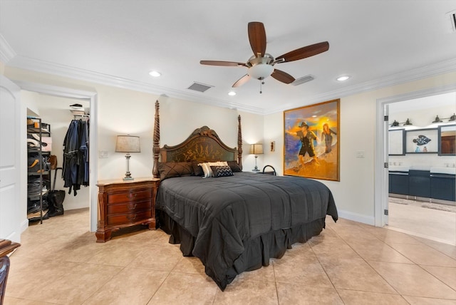 bedroom featuring ensuite bath, ceiling fan, a spacious closet, light tile patterned floors, and ornamental molding