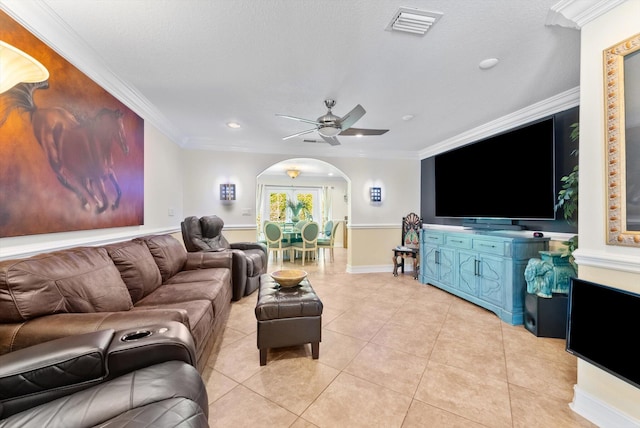 living room featuring ceiling fan, light tile patterned floors, a textured ceiling, and ornamental molding